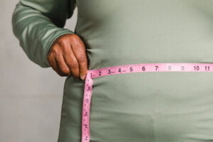 close up senior man measuring waist with tape