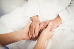 close up senior woman nurse holding hands