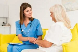 Home 52 medium shot caregiver old woman holding hands