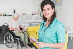 portrait female nurse holding digital tablet standing front senior patient wheelchair