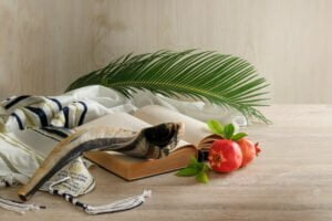 torah book shofar tallit pomegranates palm branch wooden table sunlight symbol israeli holidays