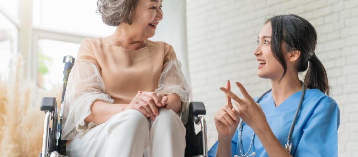 asian-young-caregiver-caring-her-elderly-patient-senior-daycare-handicap-patient-wheelchair-hospital-talking-friendly-nurse-looking-cheerful-nurse-wheeling-senior-patient