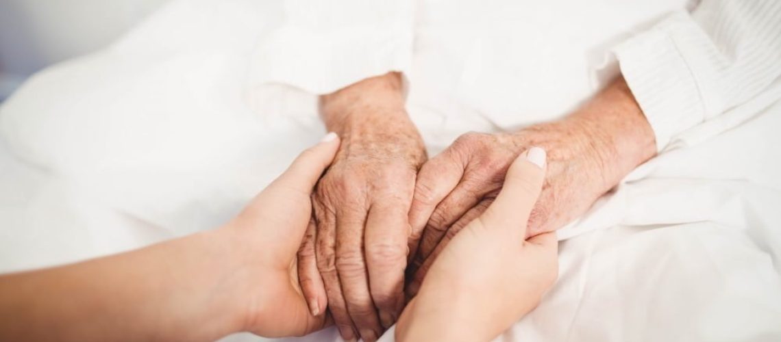 close-up-senior-woman-nurse-holding-hands