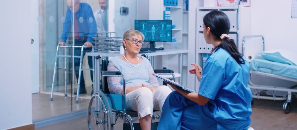 nurse-talking-with-senior-woman-with-walking-disabilities-sitting-wheelchair-into-private-modern-recovery-clinic-hospital-handicapped-old-retired-patient-medical-consultation-advice
