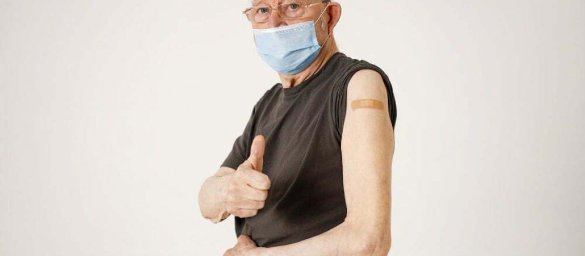 portrait-old-man-with-bandaid-shoulder-isolated-white-background