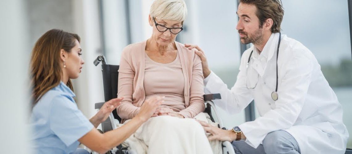 successful-doctor-young-nurse-talking-with-their-senior-female-wheelchair-bound-patient